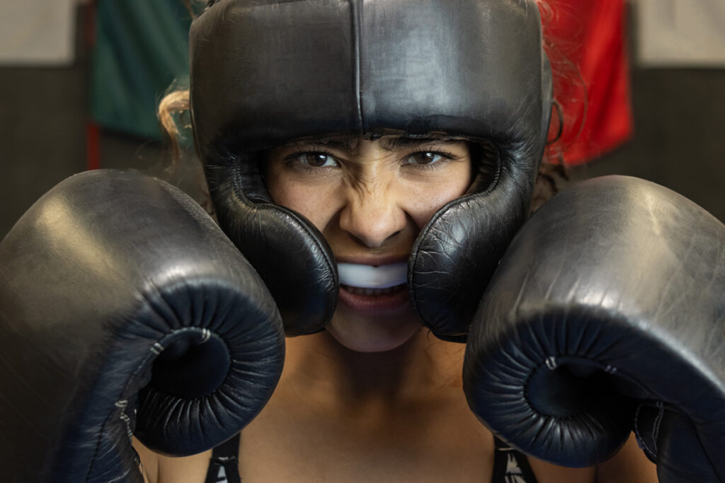 female boxer trained and using mouth guard and face shield